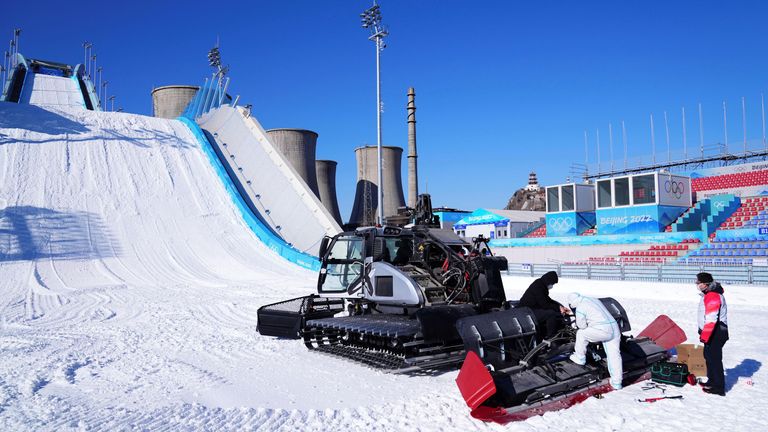 Officials check an artificial snow machine at the Big Air Shougang Winter Olympics venue in Beijing 
