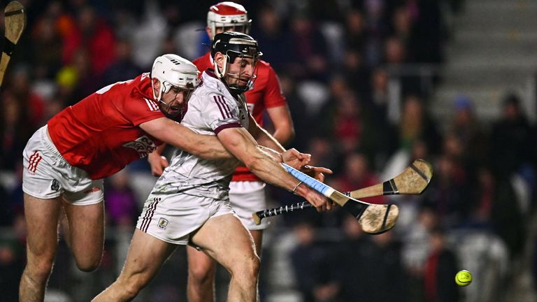Jack Hastings of Galway has a shot on goal despite the efforts of Tim O'Mahony of Cork
