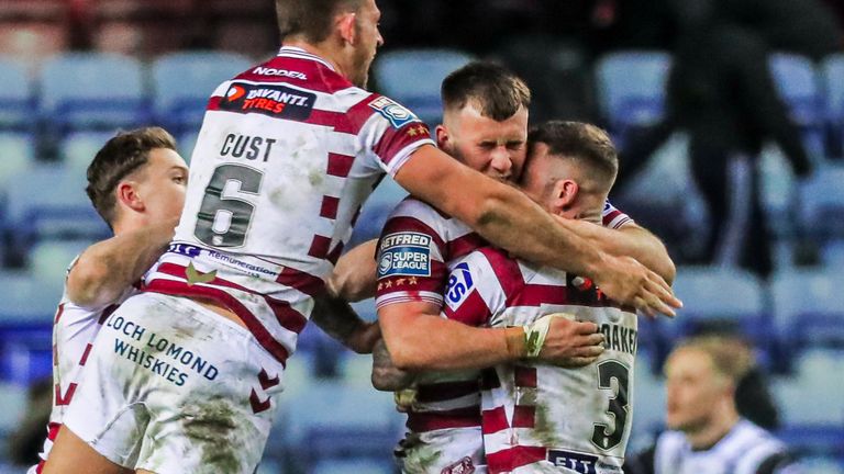 Harry Smith is mobbed by Zak Hardaker, Cade Cust and Jai Field after kicking Wigan's game-winning drop goal
