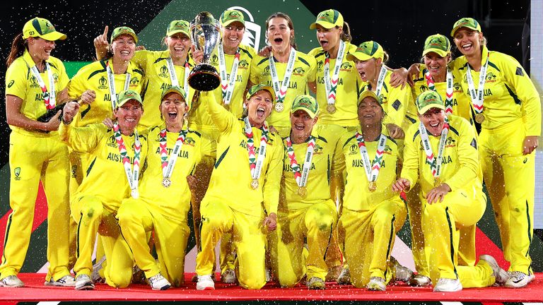 Australia celebrate with the trophy after winning the 2022 ICC Women's Cricket World Cup