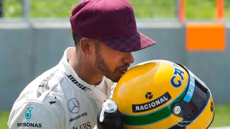 Hamilton mencium helm Senna, yang diberikan kepadanya setelah menyamai rekor pole pembalap Brasil itu