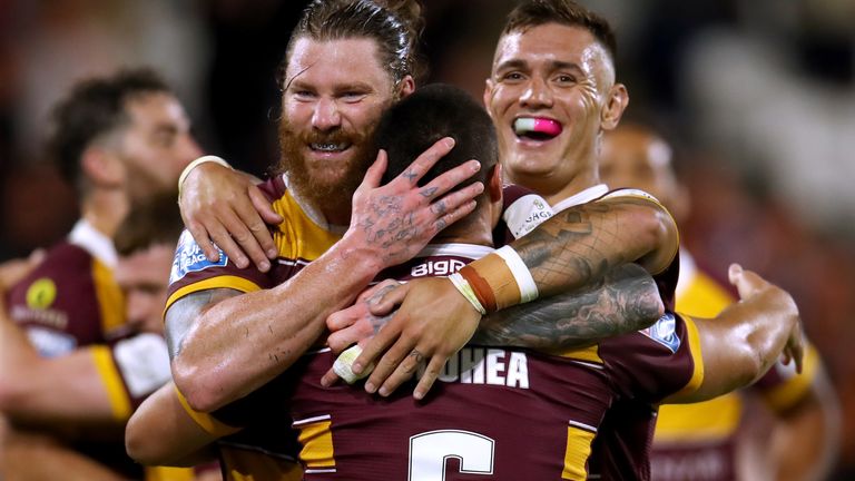 Tui Lolohea de los Gigantes de Huddersfield (de espaldas a la cámara) celebra marcar el cuarto intento del juego de sus lados durante su victoria por 36-10