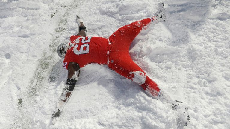 Buffalo Bills offensive lineman Vladimir Ducasse makes a snow angel after their overtime win over the Indianapolis Colts in 2018