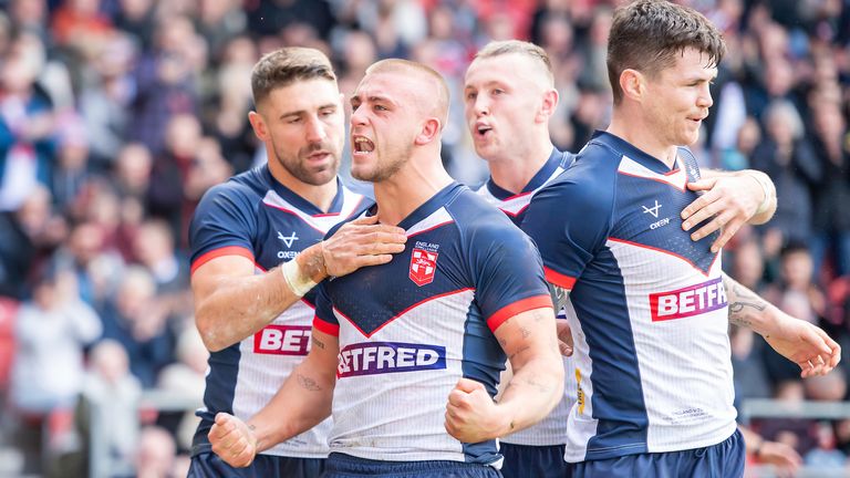 Mikey Lewis celebrates with his team-mates after scoring a try on his England debut