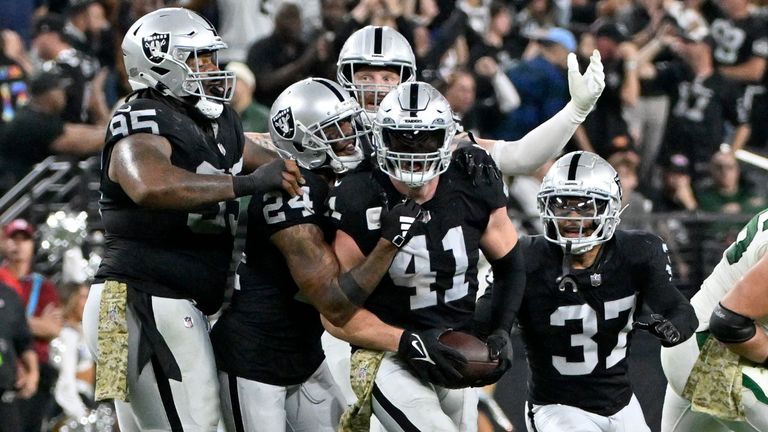 Robert Spillane is congratulated by his Raiders team-mates after intercepting a pass from the Jets' Zach Wilson