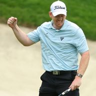 Springer celebrates after holing his birdie putt on the 18th hole for a score of 59