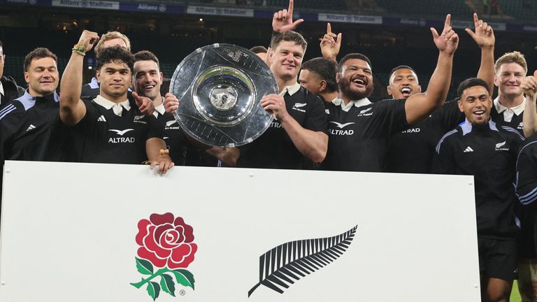 New Zealand's players celebrate with the trophy after the Autumn Nations Series victory over England