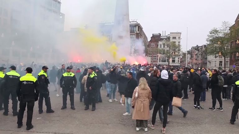 Police standing guard as Maccabi Tel Aviv supporters light flares in Dam Square