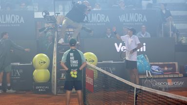 Rafael Jodar speaks with umpire Manuel Messina as smoke from fireworks at the nearby Coppa Italia final drifts in